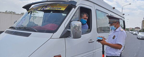 Сотрудник милиции проверяет документы у водителя маршрутки в Душанбе - Sputnik Тоҷикистон