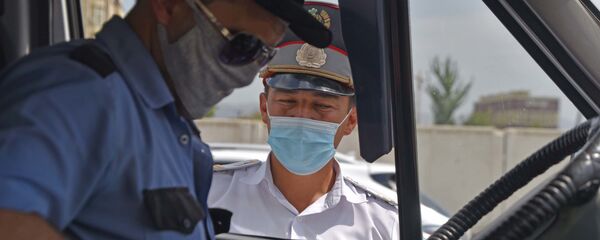 Сотрудник милиции проверяет документы у водителя маршрутки в Душанбе - Sputnik Таджикистан