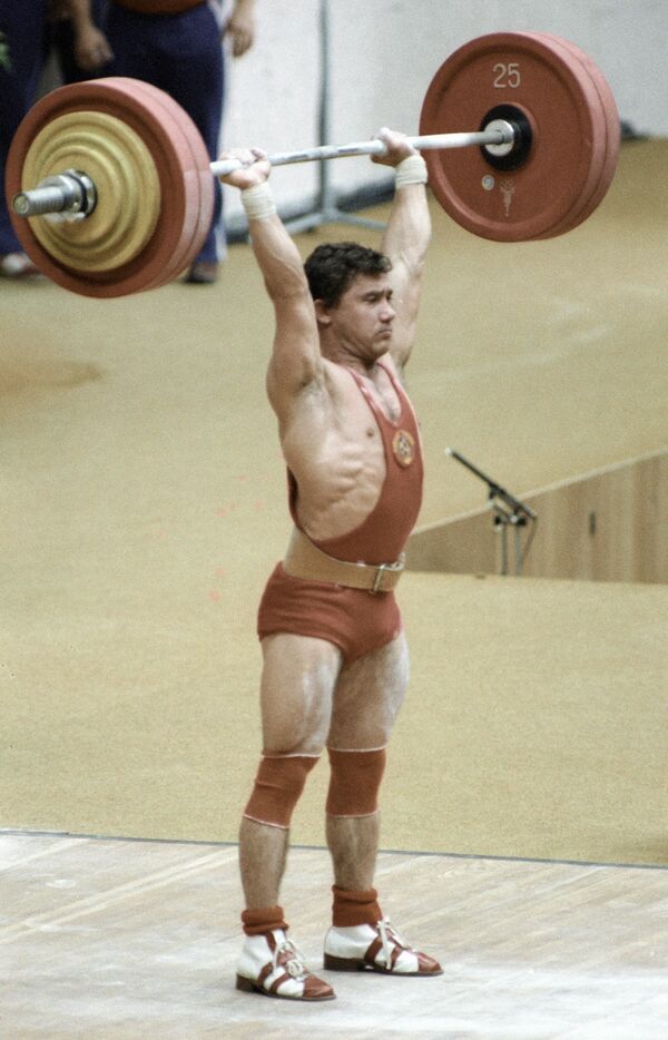 Советский штангист Виктор Мазин берет вес на соревнованиях по тяжелой атлетике во время проведения  XXII Олимпийских игр в Москве - Sputnik Таджикистан