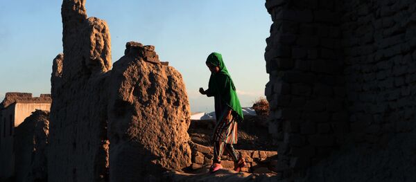 Афганская девочка проходит мимо руин здания - Sputnik Тоҷикистон