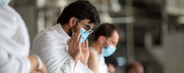 Мусульманин в защитной маске молится во время хаджа - Sputnik Тоҷикистон