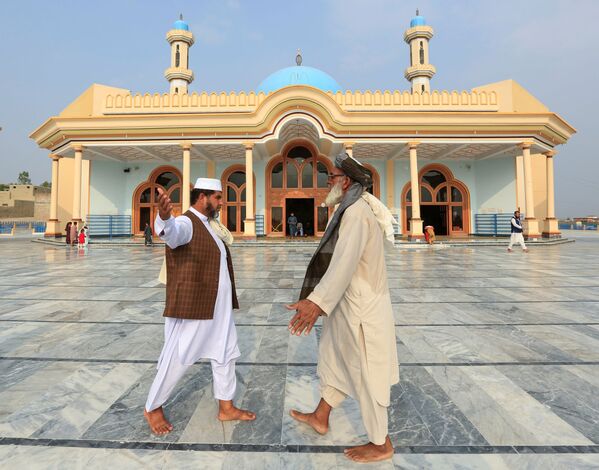 Афганские мужчины приветствуют друг друга возле мечети после молитвы по случаю празднования Курбан-байрама в Джалал-Абаде, Афганистан - Sputnik Таджикистан