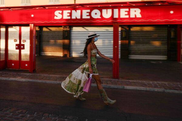 А вот во Франции соблюдают предписанные меры ВОЗ. Девушка в защитной маске у закрытого кафе Le Cafe Senequier на набережной в Сен-Тропе - Sputnik Таджикистан