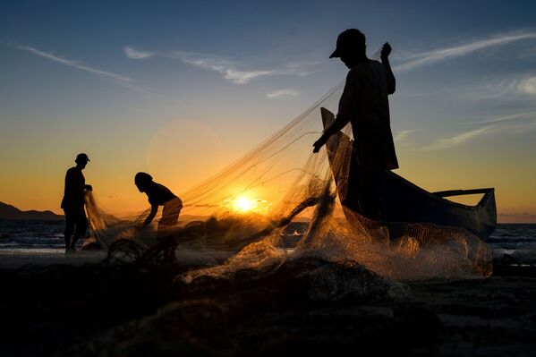 Рыбаки чистят сети после рыбалки на закате в Банда-Ачех, в Индонезии - Sputnik Таджикистан