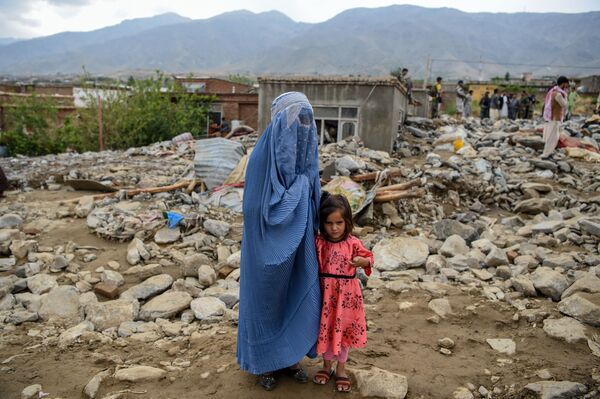  Женщина с ребенком у разрушенного здания после наводнения в Афганистане - Sputnik Тоҷикистон