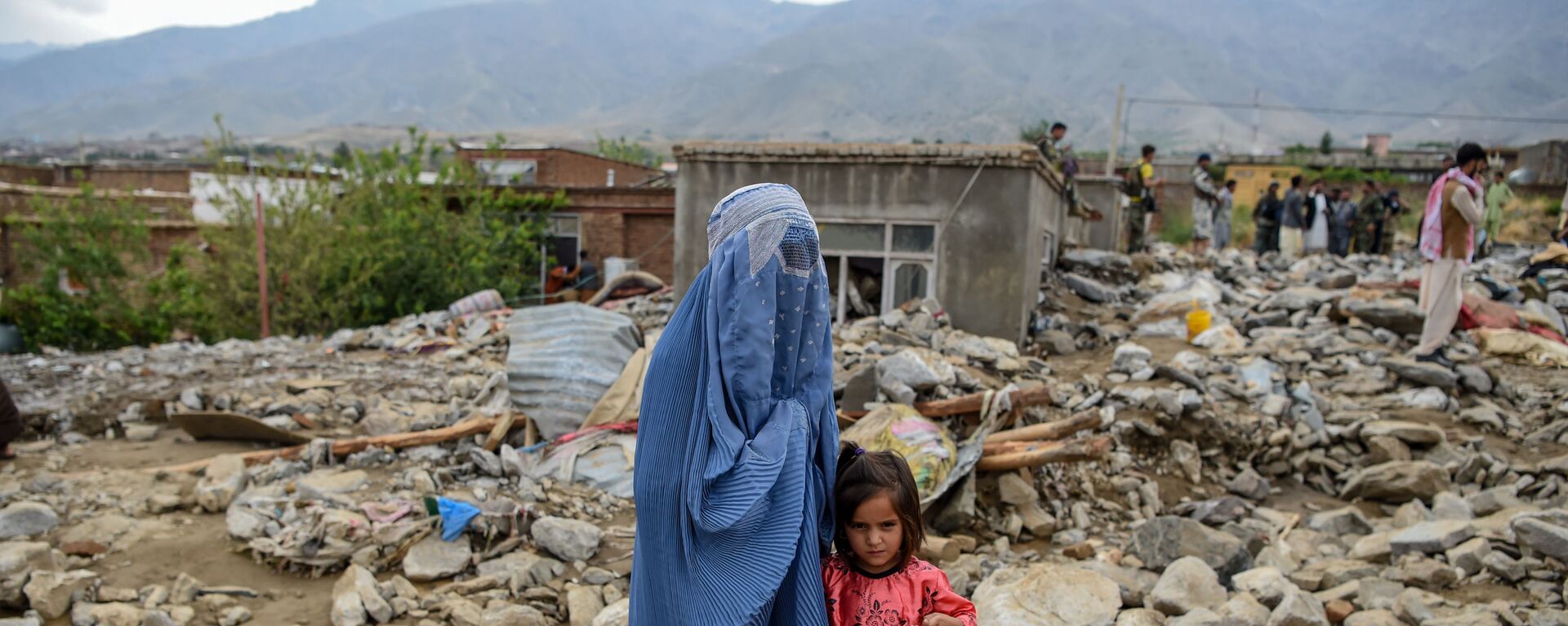  Женщина с ребенком у разрушенного здания после наводнения в Афганистане - Sputnik Тоҷикистон, 1920, 22.06.2022