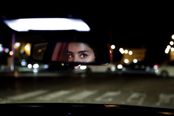 Глаза девушки в зеркале заднего вида машины в Саудовской Аравии  - Sputnik Таджикистан