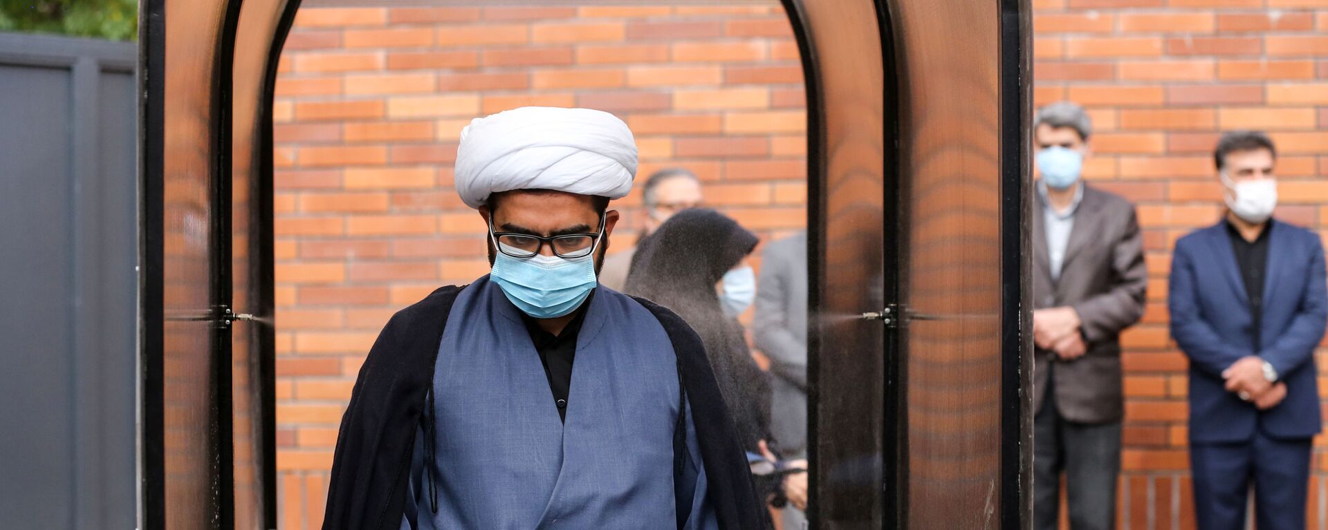Иранский чиновник в маске во время прохождения дезинфекции в школе в Тегеране  - Sputnik Тоҷикистон, 1920, 11.07.2021