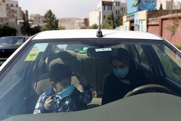 Ученик первого класса с матерью в машине в первый учебный день в школе в Тегеране  - Sputnik Таджикистан