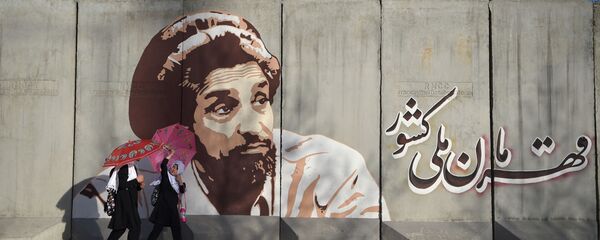 Школьницы идут по улице Кабула на фоне граффити с изображением Ахмада Шах Масуда - Sputnik Таджикистан