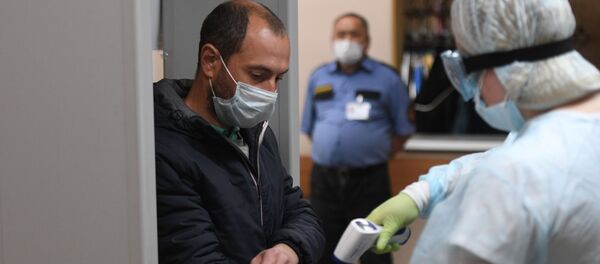 Медицинский работник измеряет температуру у мужчины Медицинский работник измеряет температуру у мужчины - Sputnik Таджикистан