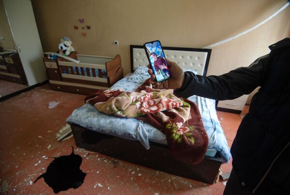 Фотография ребенка, который лежал в кроватке в момент попадания снаряда в дом в общине Иванян Нагорного Карабаха - Sputnik Тоҷикистон