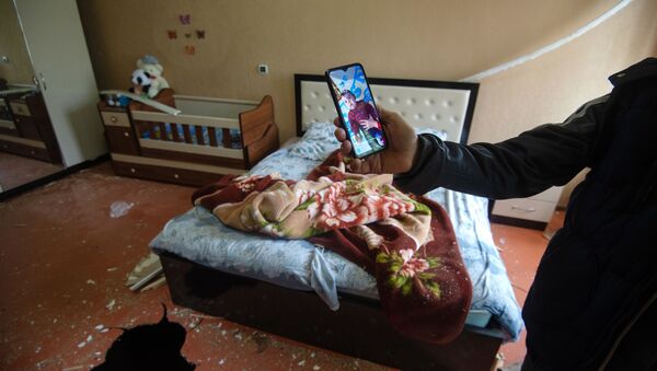Фотография ребенка, который лежал в кроватке в момент попадания снаряда в дом в общине Иванян Нагорного Карабаха - Sputnik Тоҷикистон