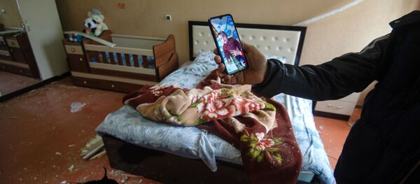 Фотография ребенка, который лежал в кроватке в момент попадания снаряда в дом в общине Иванян Нагорного Карабаха Фотография ребенка, который лежал в кроватке в момент попадания снаряда в дом в общине Иванян Нагорного Карабаха - Sputnik Тоҷикистон