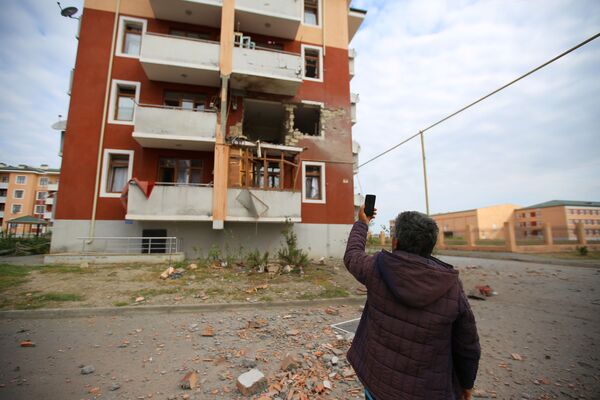 Житель азербайджанского города Тертер показывает на разрушения в жилом доме после обстрела со стороны сил обороны Нагорного Карабаха - Sputnik Таджикистан