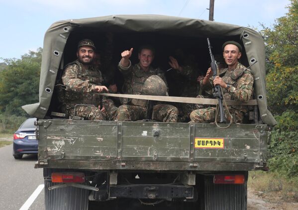 Тем временем в зону боев направляются новые подразделения. На фото - армянские добровольцы едут в Карабах - Sputnik Таджикистан