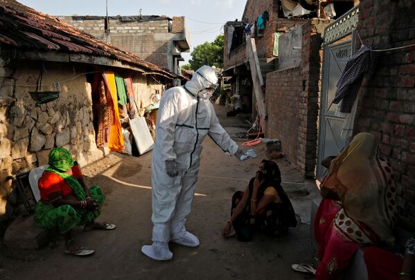 Темпы распространения коронавируса в Индии так растут, что скоро эта страна может выйти на первое место в мире по количеству зараженных. На фото - медицинские работники  проводят термоскрининг жителей бедных районов Индии - Sputnik Таджикистан