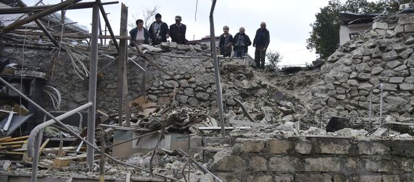 Мужчины смотрят на разрушения в жилом районе после обстрела азербайджанской артиллерией  - Sputnik Таджикистан