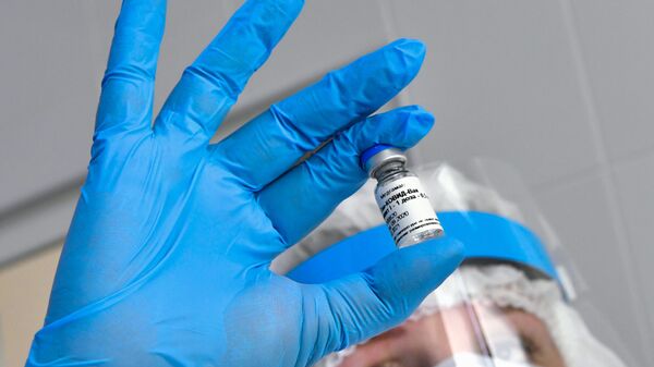 Медсестра держит в руках ампулу с вакциной Гам-Ковид-Вак - Sputnik Таджикистан
