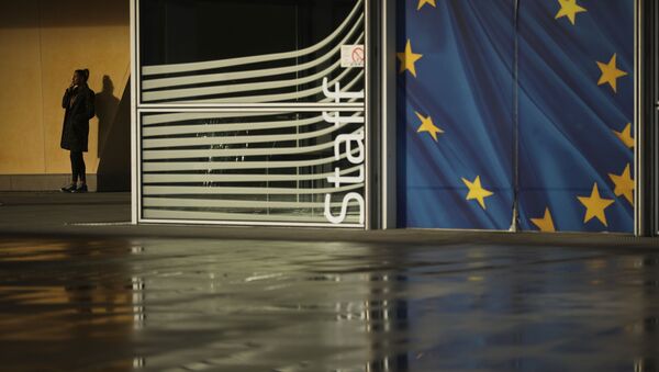 Женщина курит возле штаб-квартиры Европейской комиссии в Брюсселе - Sputnik Таджикистан