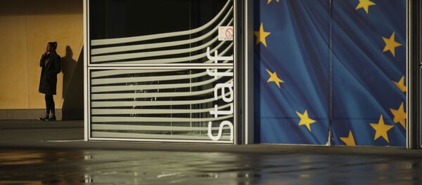 Женщина курит возле штаб-квартиры Европейской комиссии в Брюсселе - Sputnik Таджикистан