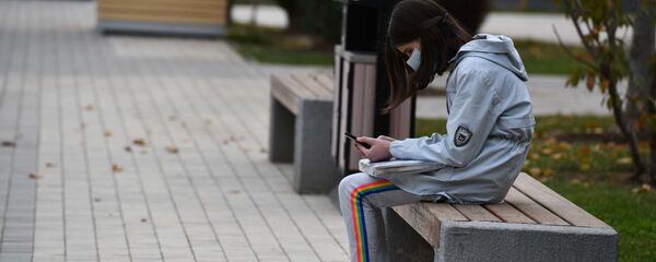 Девочка сидит на лавочке с телефоном Девочка сидит на лавочке с телефоном - Sputnik Таджикистан