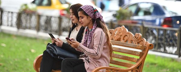 Девушки сидят на скамейке в парке - Sputnik Таджикистан