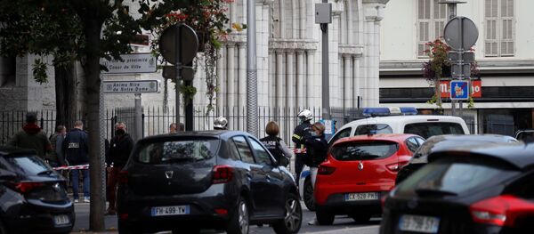 Полицейские охраняют территорию после сообщения о нападении с ножом в церкви Нотр-Дам в Ницце - Sputnik Таджикистан