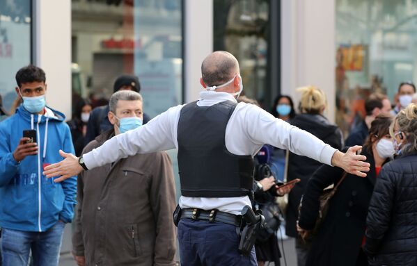 Французский полицейский оттесняет прохожих с улицы после нападения с ножом в Ницце - Sputnik Таджикистан