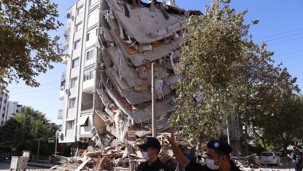 Полиция напротив разрушенного здания в результате землетрясения в Измире  - Sputnik Тоҷикистон