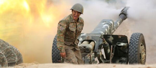 Военнослужащий стреляет из артиллерийского орудия во время боя с азербайджанскими силами в Нагорном Карабахе - Sputnik Таджикистан