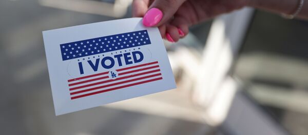 Человек держит наклейку Я проголосовал,  на президентских выборах в США - Sputnik Таджикистан