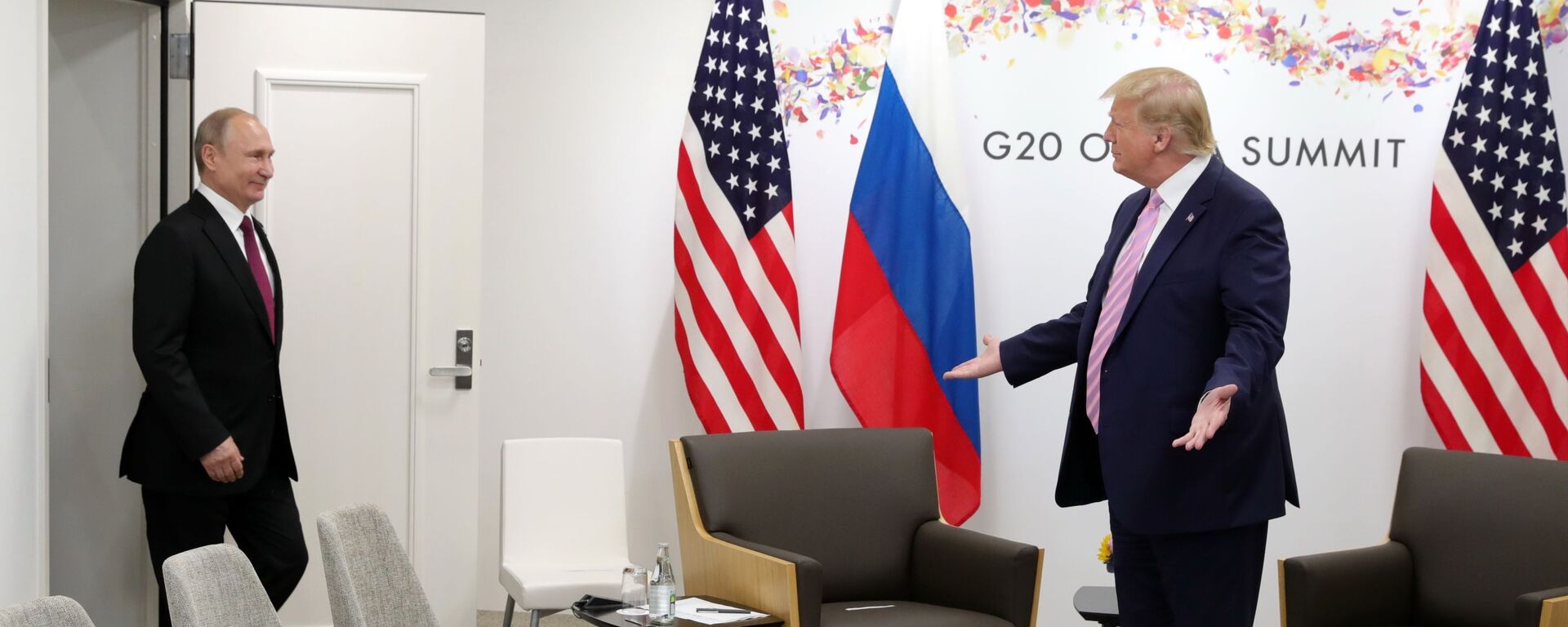 Президент США Дональд Трамп (справа) жестикулирует, когда президент России Владимир Путин прибывает на переговоры во время двусторонней встречи на полях саммита G-20 - Sputnik Таджикистан, 1920, 28.09.2021