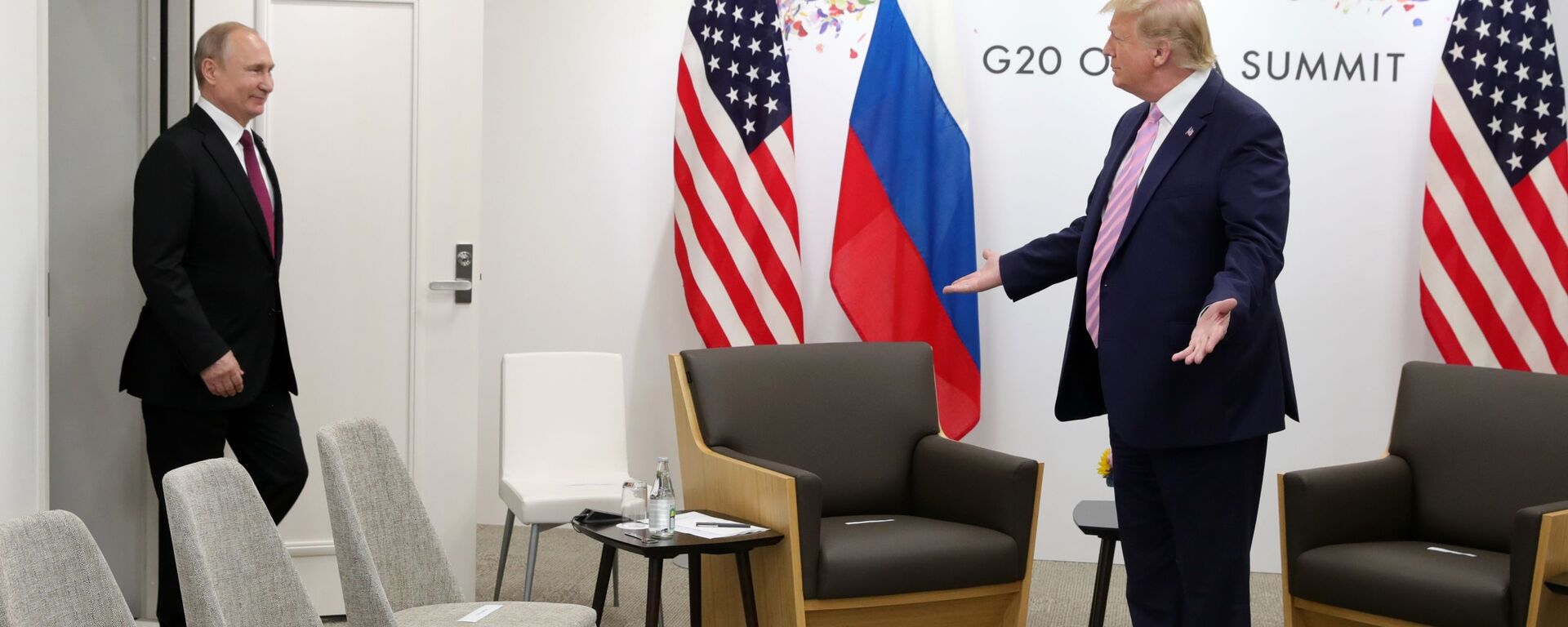Президент США Дональд Трамп (справа) жестикулирует, когда президент России Владимир Путин прибывает на переговоры во время двусторонней встречи на полях саммита G-20 - Sputnik Таджикистан, 1920, 28.09.2021
