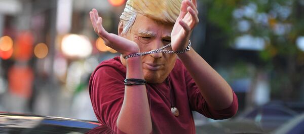 Человек в маске Дональда Трампа едет на машине по улице Нью-Йорка после новостей о победе на выборах президента США кандидата от Демократической партии Джозефа Байдена Человек в маске Дональда Трампа едет на машине по улице Нью-Йорка после новостей о победе на выборах президента США кандидата от Демократической партии Джозефа Байдена - Sputnik Таджикистан