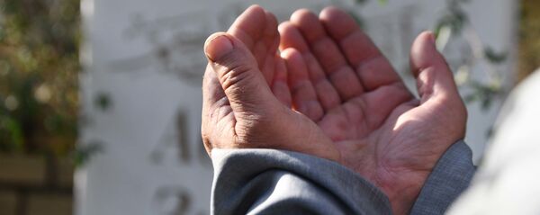 Мужчина совершает молитву на кладбище - Sputnik Тоҷикистон