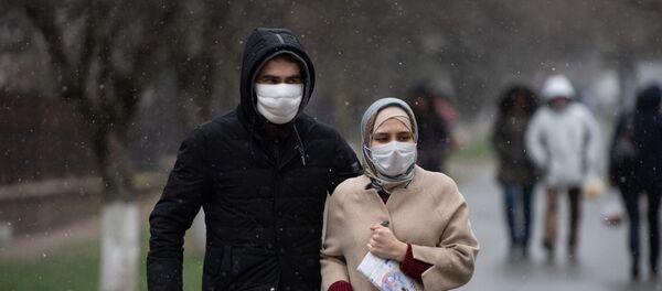 Люди в медицинских масках идут по улице  - Sputnik Тоҷикистон