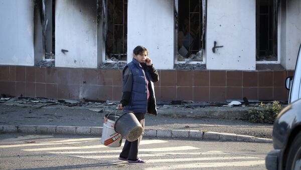 Женщина проходит мимо разрушенного дома - Sputnik Таджикистан
