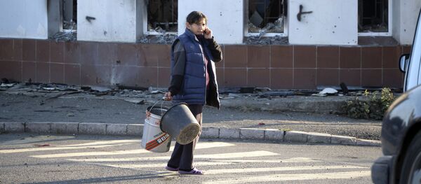 Женщина проходит мимо разрушенного дома Женщина проходит мимо разрушенного дома - Sputnik Таджикистан