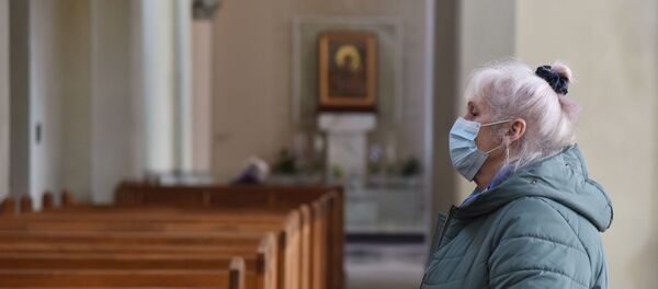 Женщина в защитной маске в одном из храмов во Львове Женщина в защитной маске в одном из храмов во Львове - Sputnik Тоҷикистон
