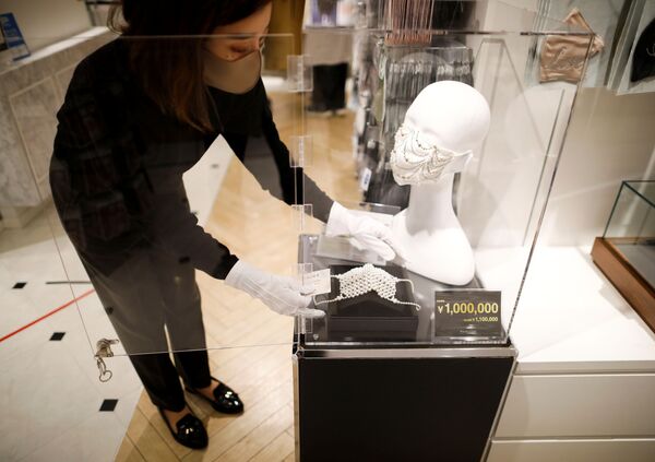 Сотрудник магазина устанавливает маску с драгоценными камнями  в Токио  - Sputnik Тоҷикистон