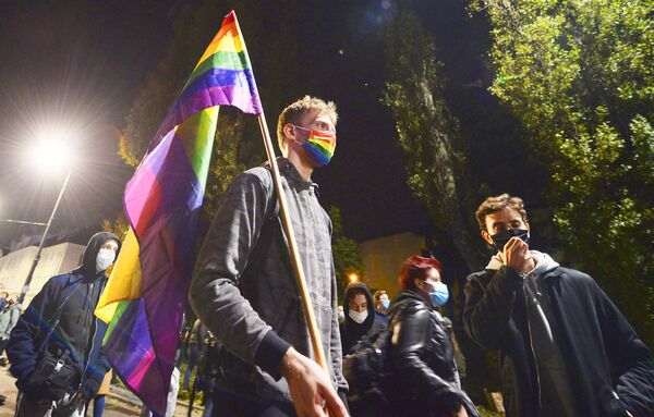 Протестующий с флагом ЛГБТ на митинге в Варшаве против решения Конституционного суда Польши об ограничении закона об абортах - Sputnik Тоҷикистон