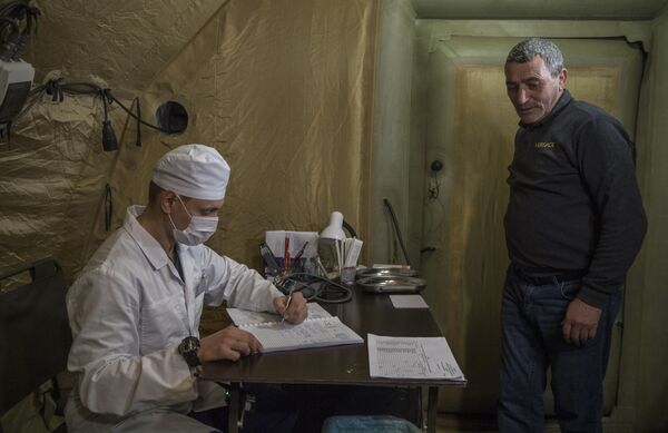 Врач проводит прием пациента на базе госпиталя развернутого Министерством обороны России на территории аэропорта в Степанакерте - Sputnik Таджикистан