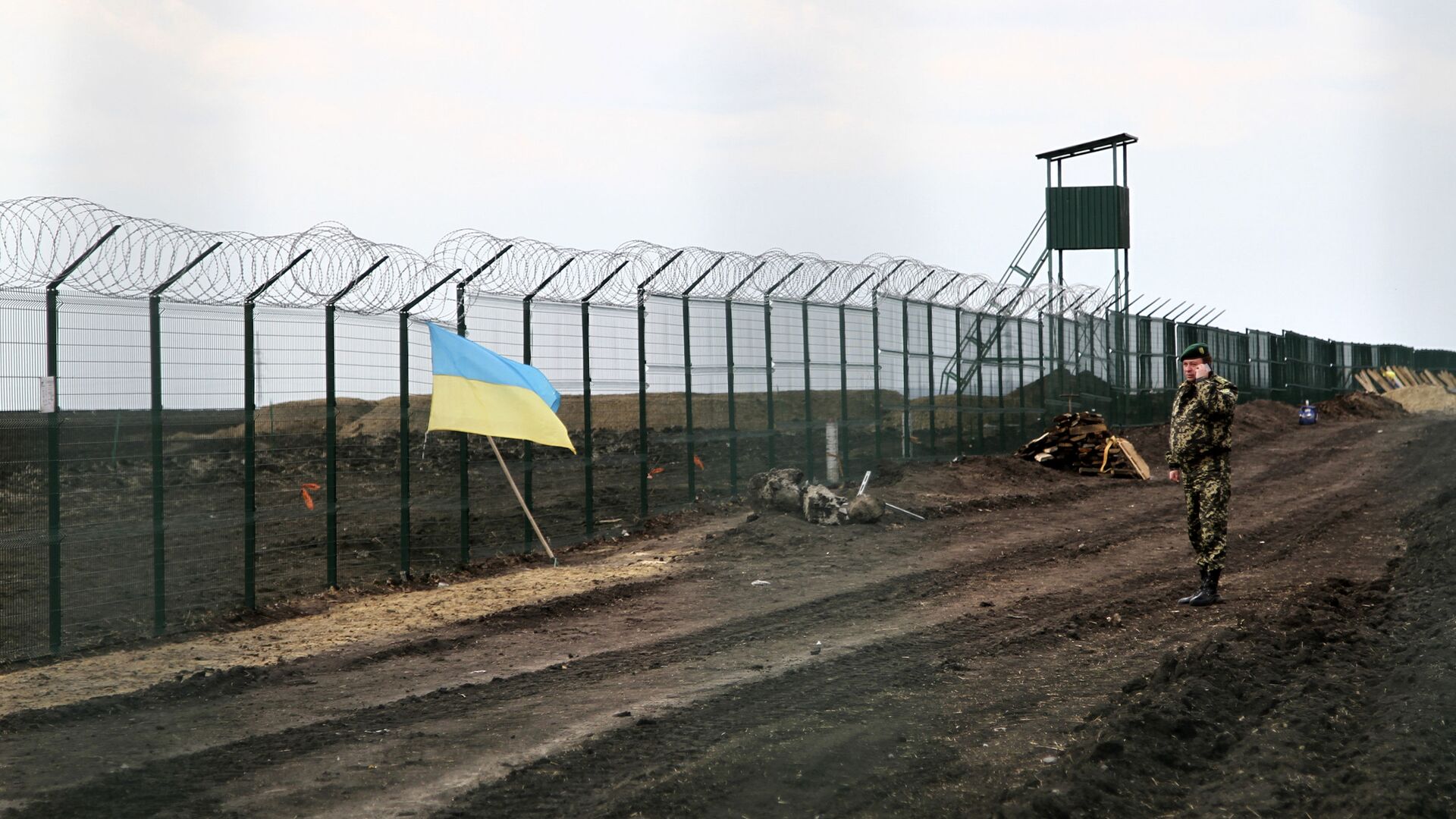 Украинский государственный флаг прикреплен к забору на украинско-российской границе - Sputnik Таджикистан, 1920, 02.03.2022