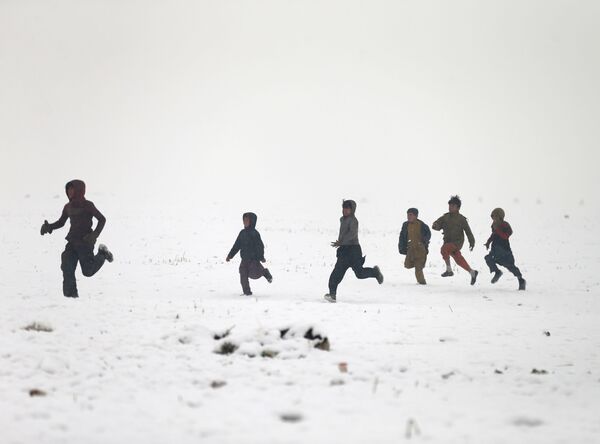 Афганские мальчики играют во время снегопада в Кабуле - Sputnik Таджикистан