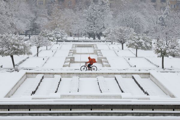 Мужчина на велосипеде во время снегопада в Софии, Болгария - Sputnik Таджикистан