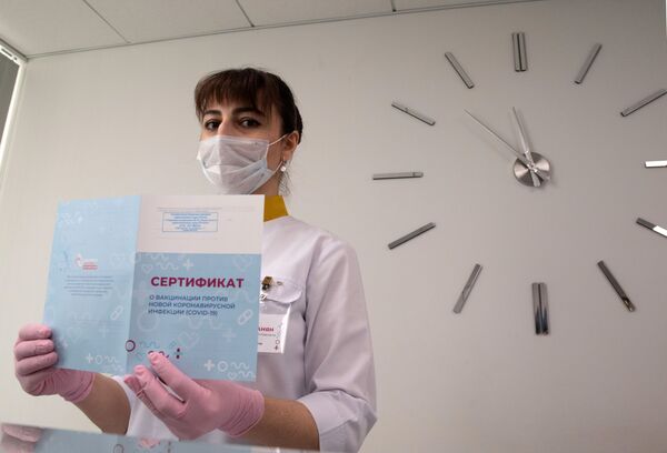 Медработник демонстрирует Сертификат о вакцинации от новой коронавируссной инфекции COVID-19 в Москве - Sputnik Тоҷикистон