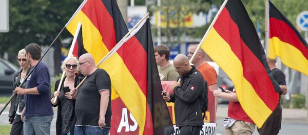 Люди проводят демонстрацию с немецкими флагами в Германии - Sputnik Таджикистан
