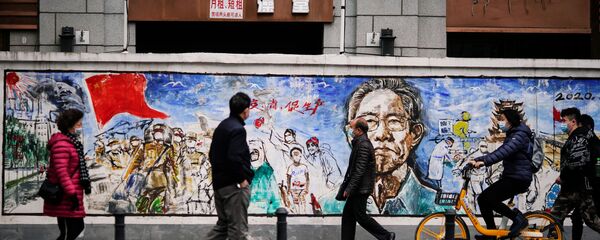 Люди в масках напротив граффити в Ухане почти год после начала пандемии  - Sputnik Таджикистан