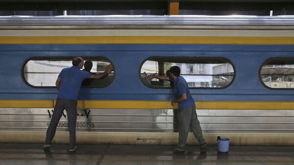 Двое рабочих моют окна у вагоне поезда на центральном вокзале Тегерана - Sputnik Таджикистан